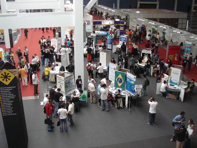 View of the show floor at FISL, including a large poster of the Linux \